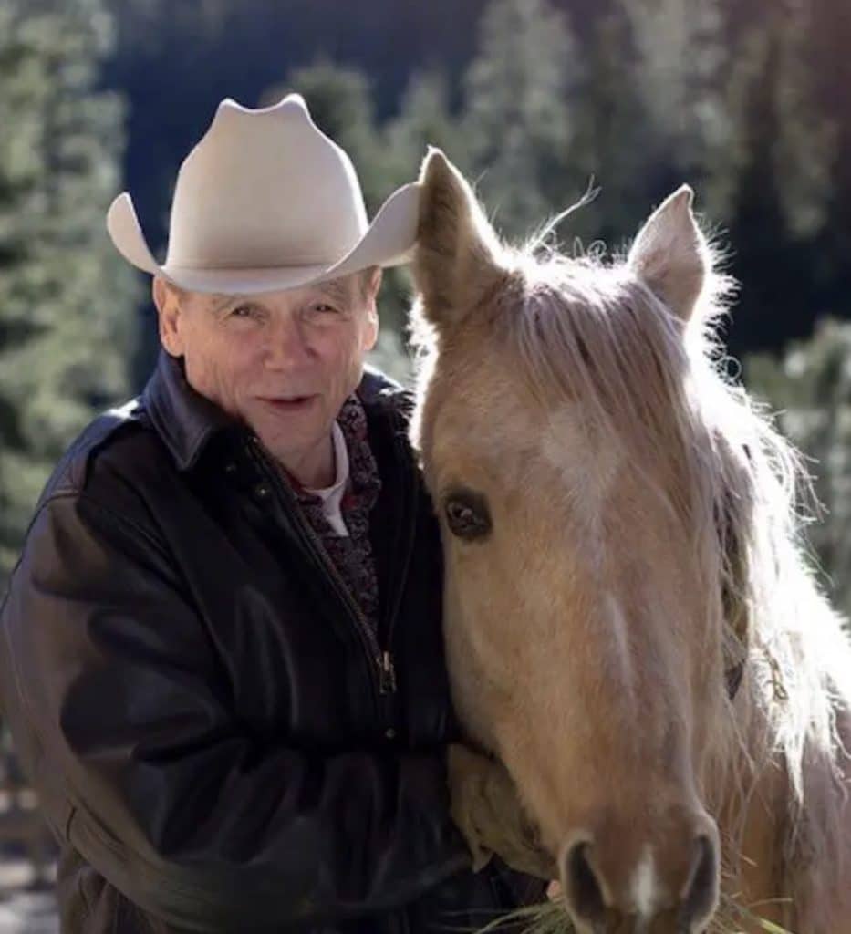 L’écrivain américain James Lee Burke debout à côté de son cheval